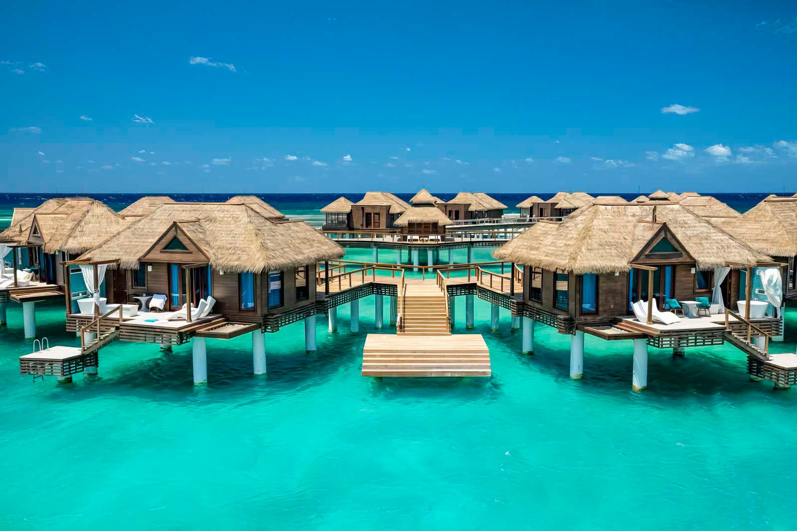 Floating bungalow on Sandals Royal Caribbean’s private island with overwater hammock and vibrant reef below