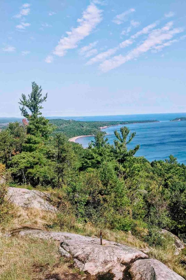 The breathtaking 360-degree panoramic view from the summit of Sugarloaf Mountain, overlooking Lake Superior and the forests of the UP