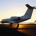 Private jet on a runway at sunset