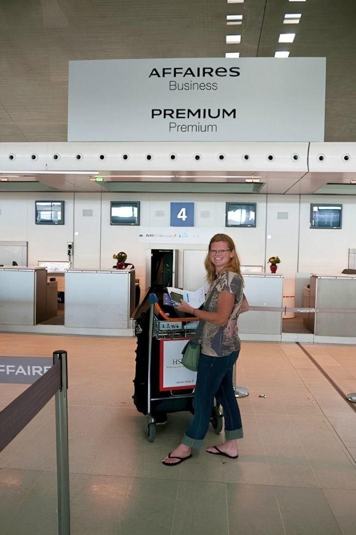 Traveler checking luggage at an airport counter where passengers should photograph the baggage tag before the suitcase goes behind the scenes.